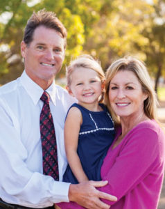 Man, woman, and child smiling outside